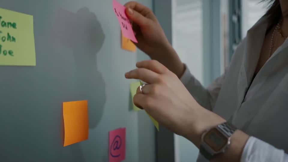 Colleagues planning against a wall of sticky notes